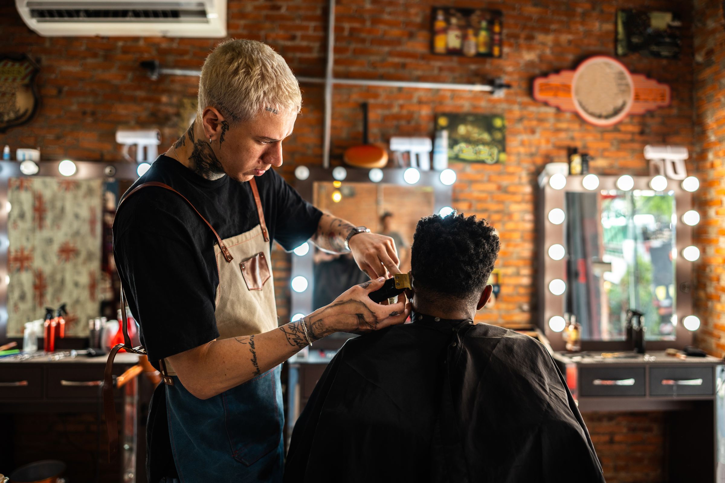 A barber trimming a client’s beard in a shop
